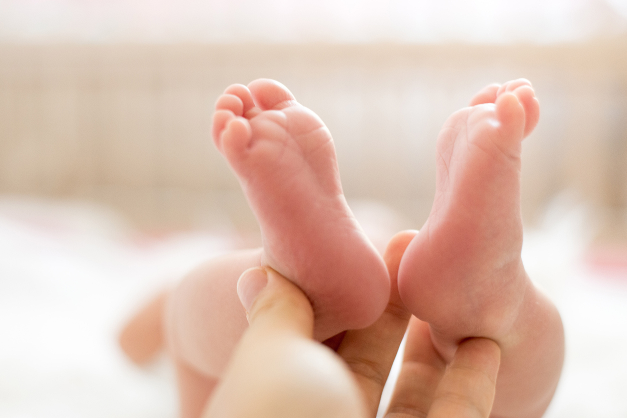 Baby feet in mother hands. Mom and her Child. Beautiful conceptual image of Maternity
